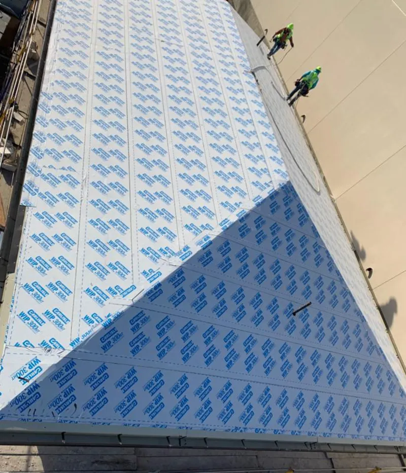 Professional roofers installing underlayment on a metal roof in Hollister
